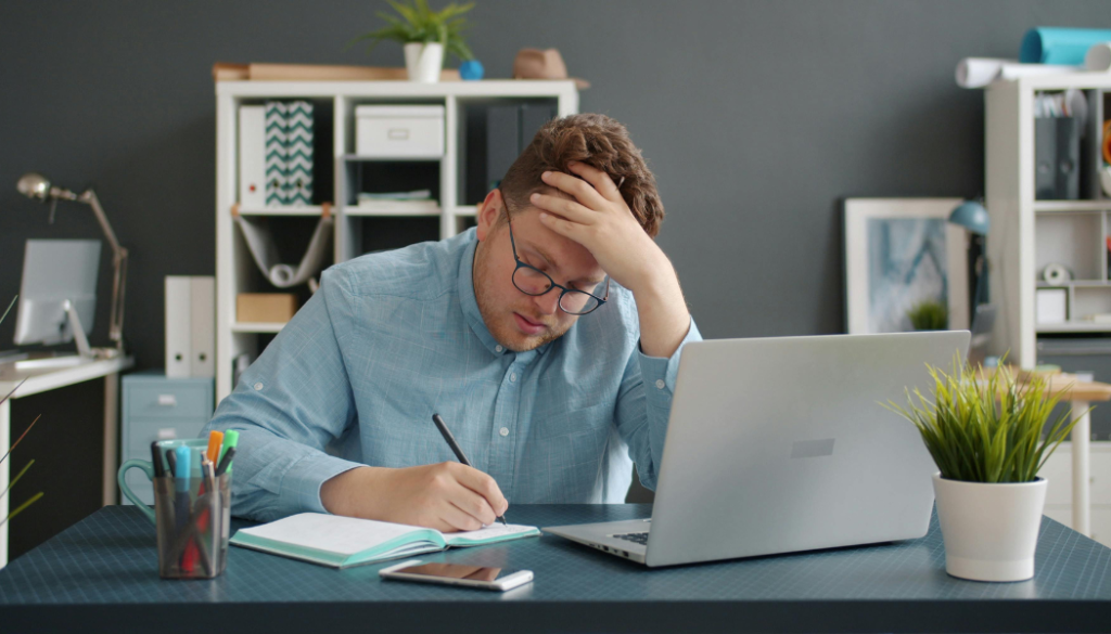 Business owner feeling overwhelmed by marketing challenges while working at a desk