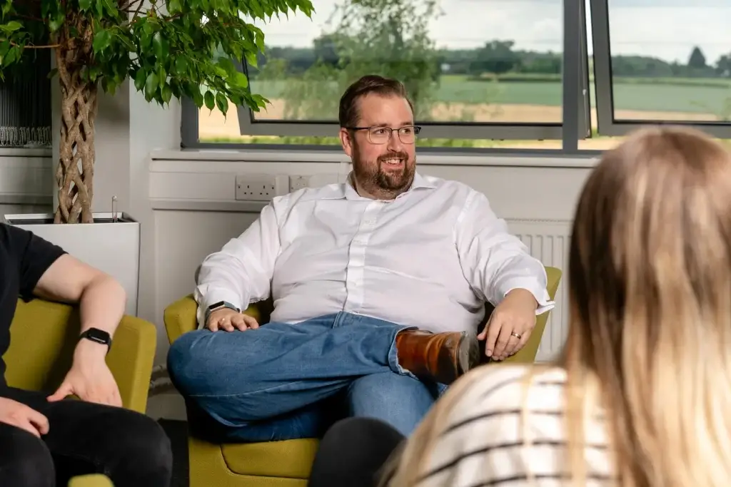 Chris chatting with two people in a bright meeting area