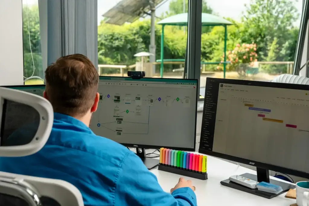Chris working on an automation flow and a project timeline across two screens